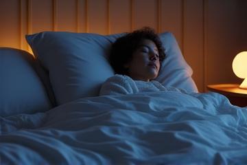 Persona rilassata che dorme serenamente in un letto confortevole, con luce soffusa.